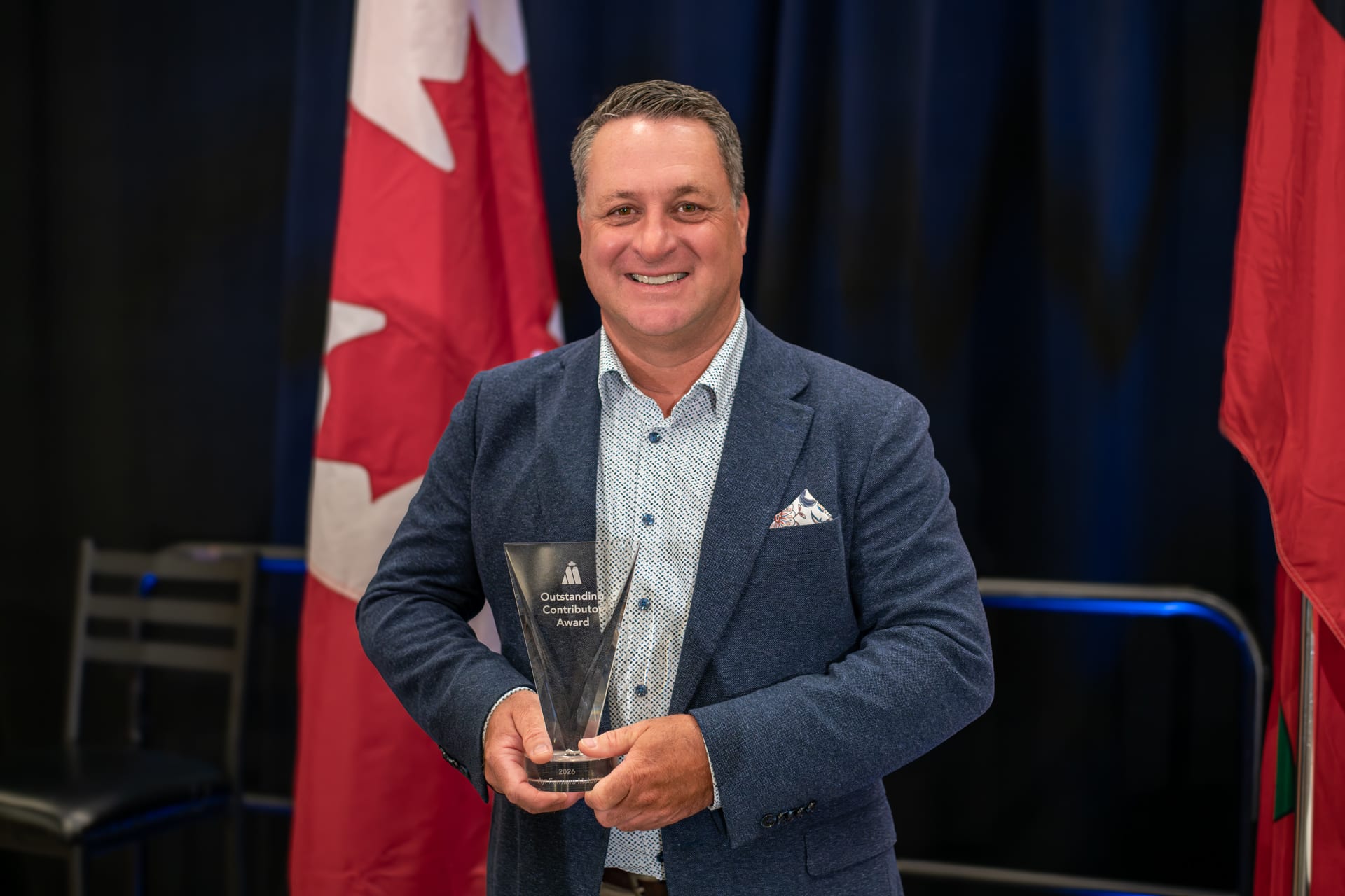 Jeff Whiting, President & CEO of Ayr Farmers Mutual, after being presented with the 2026 Outstanding Contributor Award